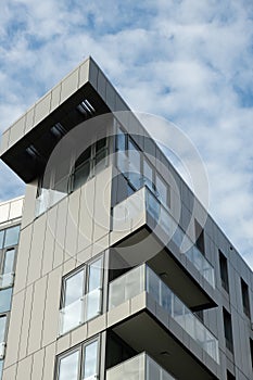 Modern office building exterior with glass facade on clear sky background. Transparent glass wall of office building