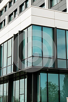 Modern office building exterior with glass facade on clear sky background. Transparent glass wall of office building