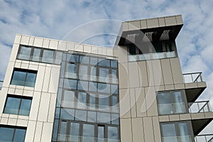 Modern office building exterior with glass facade on clear sky background. Transparent glass wall of office building