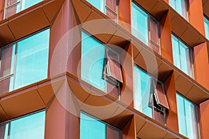 Modern office building exterior with glass facade on clear sky background. Transparent glass wall of office building