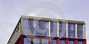Modern office building exterior with glass facade on clear sky background. Transparent glass wall of office building
