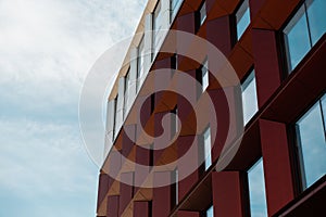 Modern office building exterior with glass facade on clear sky background. Transparent glass wall of office building