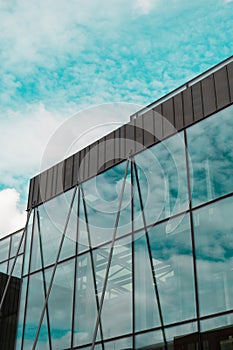 Modern office building exterior with glass facade on clear sky background. Transparent glass wall of office building