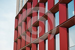 Modern office building exterior with glass facade on clear sky background. Transparent glass wall of office building