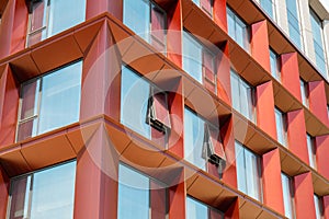 Modern office building exterior with glass facade on clear sky background. Transparent glass wall of office building