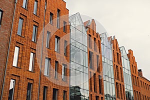 Modern office building exterior with glass facade on clear sky background. Transparent glass wall of office building