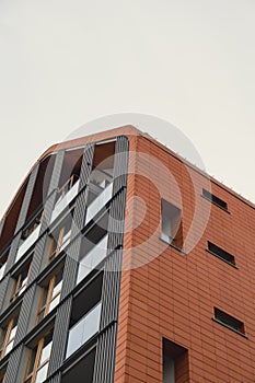 Modern office building exterior with glass facade on clear sky background. Transparent glass wall of office building