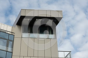 Modern office building exterior with glass facade on clear sky background. Transparent glass wall of office building