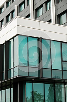 Modern office building exterior with glass facade on clear sky background. Transparent glass wall of office building