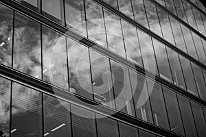 Modern office building glass facade, sky reflection in windows. Skyscrapers urban skyline. Architectural details. High