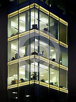 modern office building illuminated at night with geometric windows