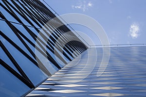 Modern office building made from glass and steel. Low angle view. Sky background.