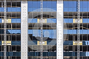 Modern office building under construction. blue sky reflection in glass facade