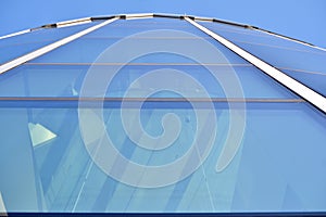 Modern office building wall made of steel and glass with blue sky