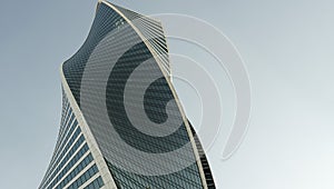 Modern office building wall made of steel and glass with blue sky copy space