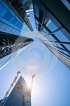 Modern office buildings skyscraper with cranes construction machinery