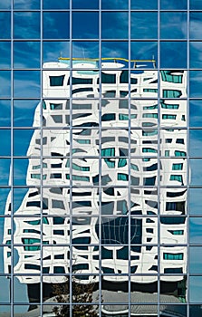 Modern office builing reflected in a glass facade