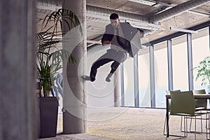 In the modern office, a businessman with a briefcase captivates everyone as he performs thrilling aerial acrobatics photo