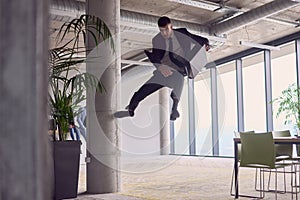 In the modern office, a businessman with a briefcase captivates everyone as he performs thrilling aerial acrobatics photo