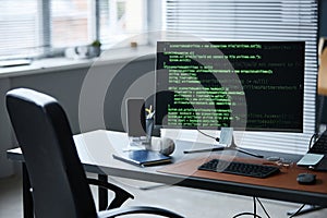 Modern Office Desk Featuring Smartphone and Baseball Beside Coding Monitor