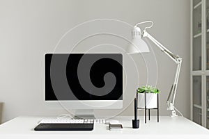 Modern office desk table. Desktop computer, white lamp, graphics tablet, keyboard, mouse, pen and succulent plant. Copy space.