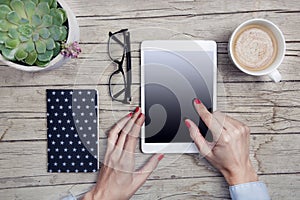 Modern office desk with tablet, handy, notepad and cup of coffee