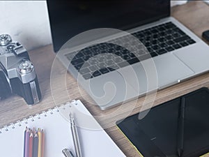 modern office desktop with office equipment,laptop computer, smart phone, camera on wooden table background.