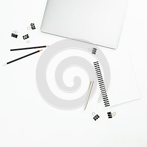 Modern office desktop workspace with laptop, notebook and accessories on white background. Top view. Flat lay.