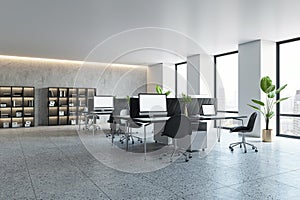 Modern office interior with desks, computers, and large windows, empty design space with natural lighting, corporate workplace