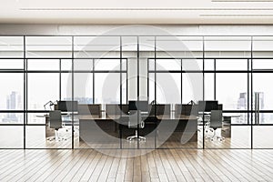 Modern office interior with glass partitions, city view through large windows, and empty workspaces on a wood-toned floor, concept