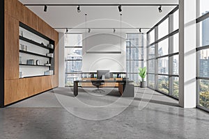 Modern office interior with work desk near window, pc desktop and sideboard