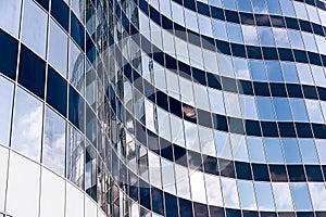 Modern office skyscraper with glass windows and sky reflection