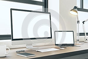 Modern office workplace with computer and laptop on desktop