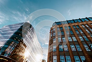 Modern offices and old middle of XX century buildings neighborhood with blue sky background.