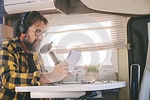 Modern online work in alternative office lifestyle. Traveler use online connection for his job. Man recording and speaking at the