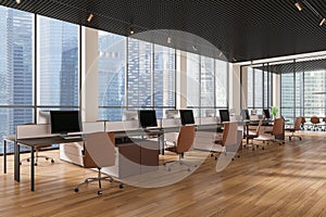 Modern open office space with several workstations and computers, large windows showcasing city buildings, concept of productivity photo