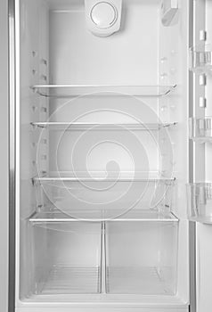 Modern open refrigerator with empty shelves