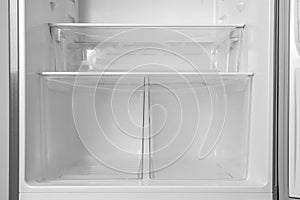 Modern open refrigerator with empty shelves