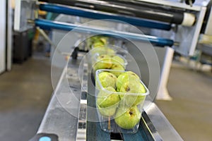 Modern packaging machine for fresh pears in a factory for food industry