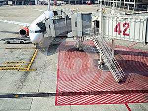 Modern passenger airplane parked to terminal building gate