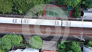 Modern passenger Train crossing the frame In high speed, Top down aerial view