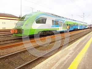 Modern passenger train en route. Worker inspects the railway line. High-speed train with motion blur. Train at the railway station