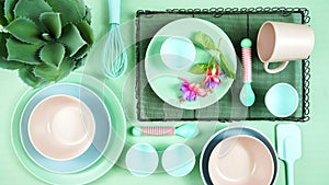 Modern pastel pink, green and blue ceramic tableware set on pale green.