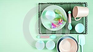 Modern pastel pink, green and blue ceramic tableware set on pale green.