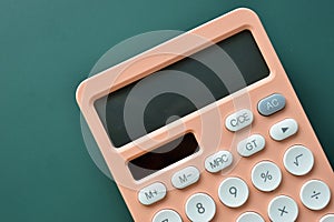 modern peach colour pastel calculator and white button on green background, finance accounting concept