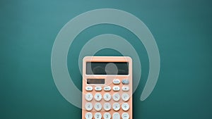 modern peach colour pastel calculator and white button on green background, finance accounting concept