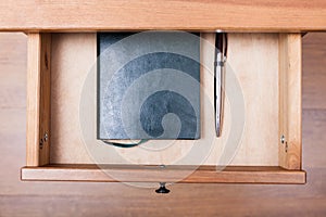 Modern pen and notebook in open drawer