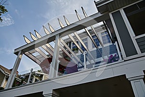 Modern Pergola Detail with Floral Balcony Against Blue Sky photo