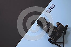 Modern photography camera and memory on black and blue background