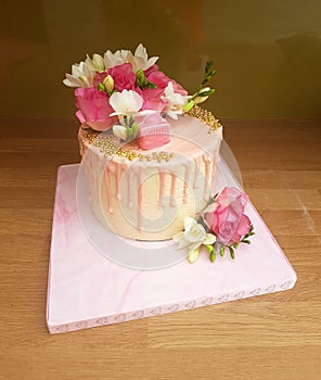 Modern pink drip cake with fresh flowers